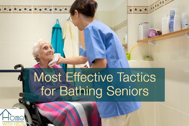 Elderly woman in wheel chair with caretaker touching face with wash cloth. Text reads: "most effective tactics for bathing seniors"