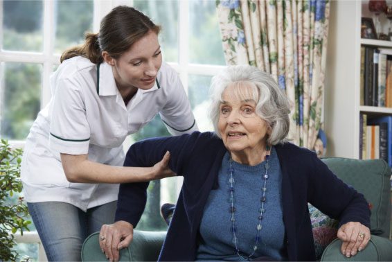 Caregiver Assisisting Old Woman with Alzheimers in Standing
