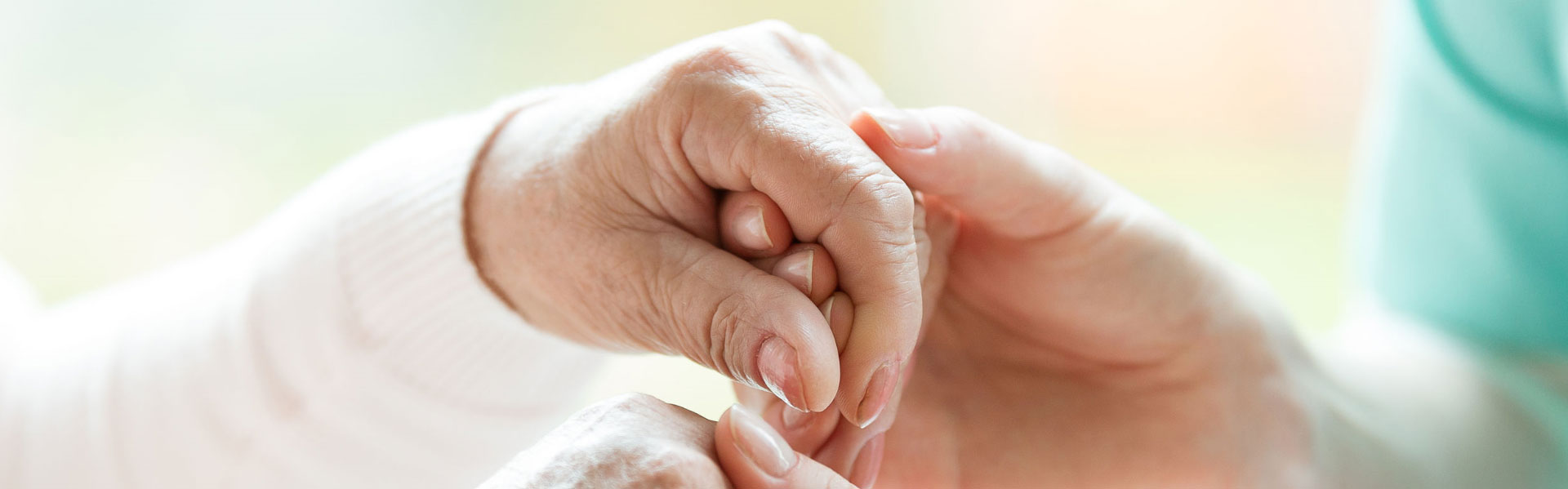 Old-woman-and-caregiver-hold-hands